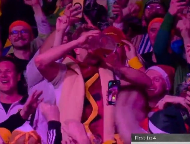 Darts star Nathan Aspinall stops mid-game to watch a fan drinking a mug of beer, before winning the third round clash at Ally Pally.