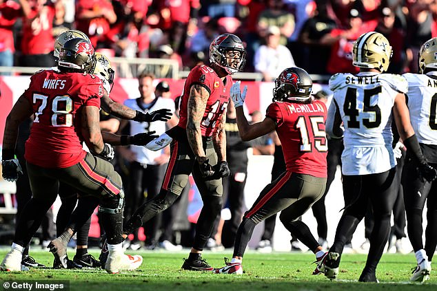 The NFL star is mobbed by his teammates after a late sack secures him a  million bonus and extends his historic streak to 11 years.