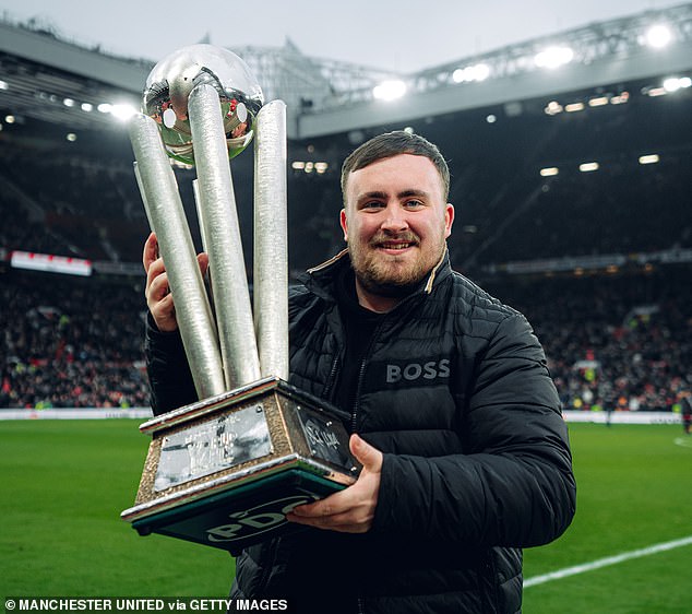 Luke Littler displays the World Darts Championship trophy around Old Trafford at half-time of Man United's clash with Brighton